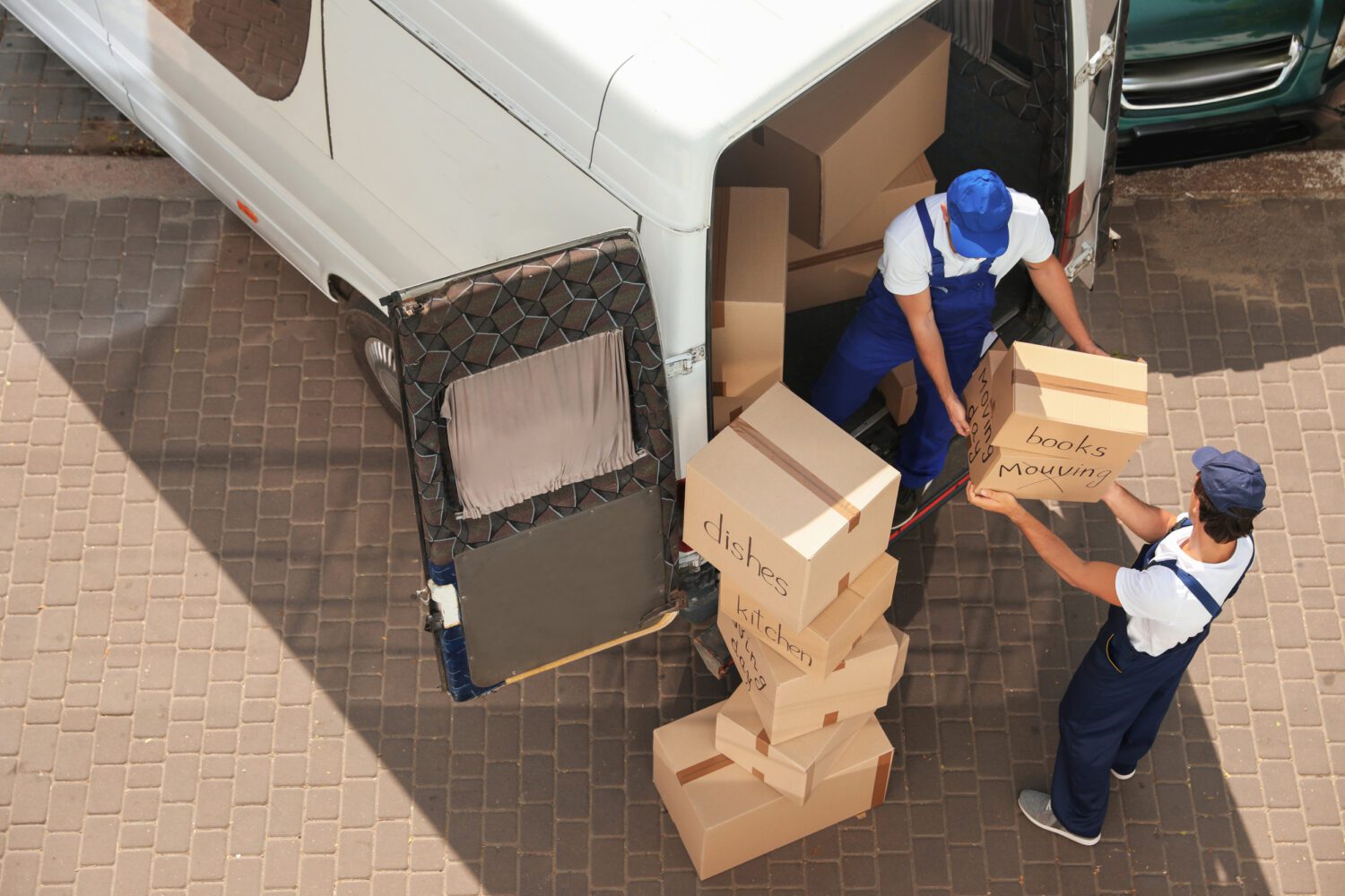 Movers Unloading Boxes From Van Outdoors